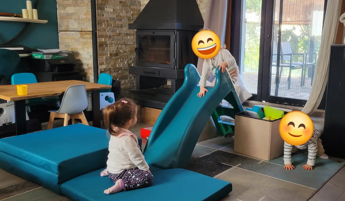 Espace extérieur avec cabane, petits jeux et table de pique-nique.