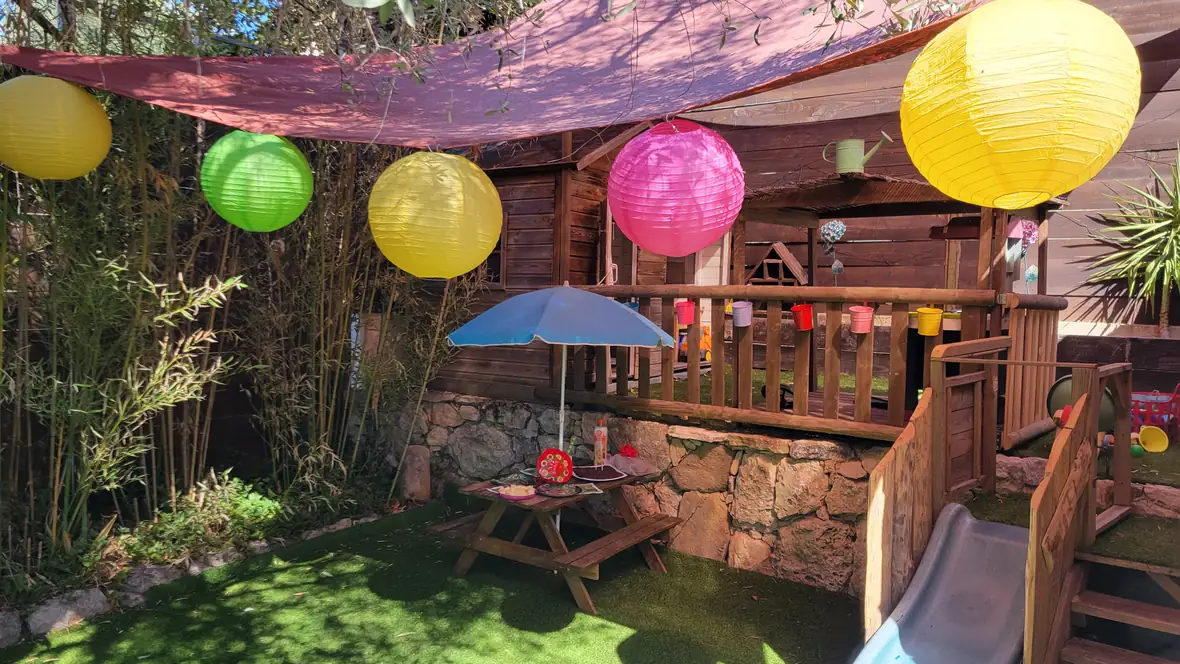 Jardin aménagé avec cabane et jeux.